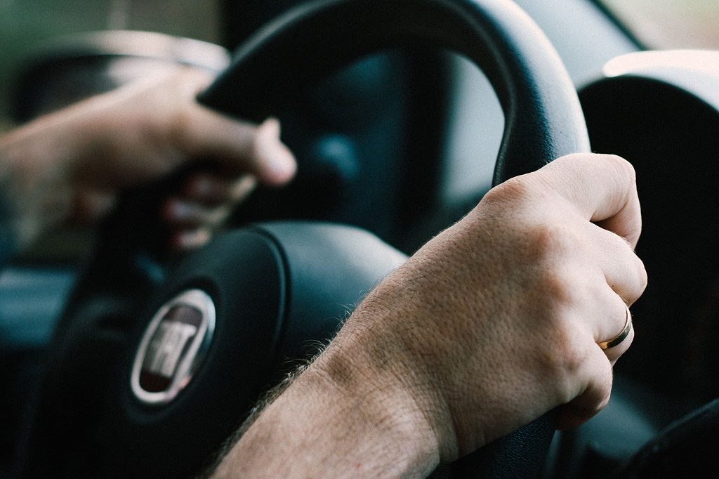 Close up of driver's hands on a steering wheel as they drive in the EU.