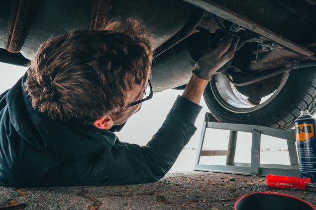 Mechanic under car during an MOT inspection