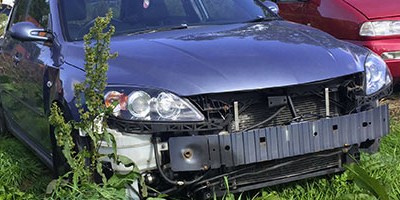 Damaged car parked in field